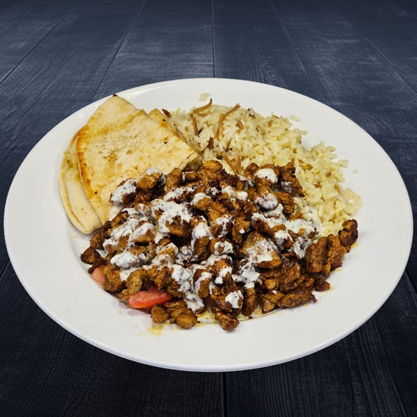 A Greek chicken gyro plate with rice, pita bread, and tzatziki sauce on a white plate.