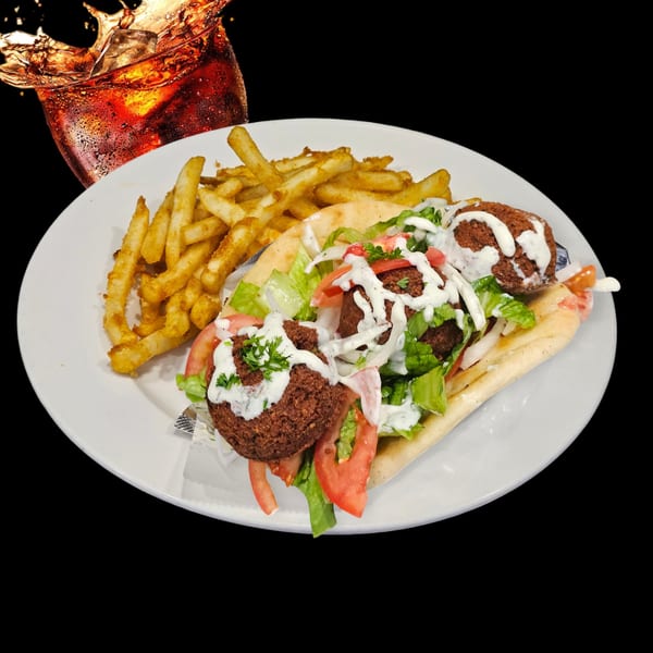 Falafel pita with lettuce, tomatoes, onions, tzatziki, and a side of fries and a drink.