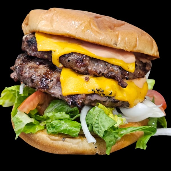 A double cheeseburger with melted cheese, lettuce, tomato, onion, and sauce on a bun.