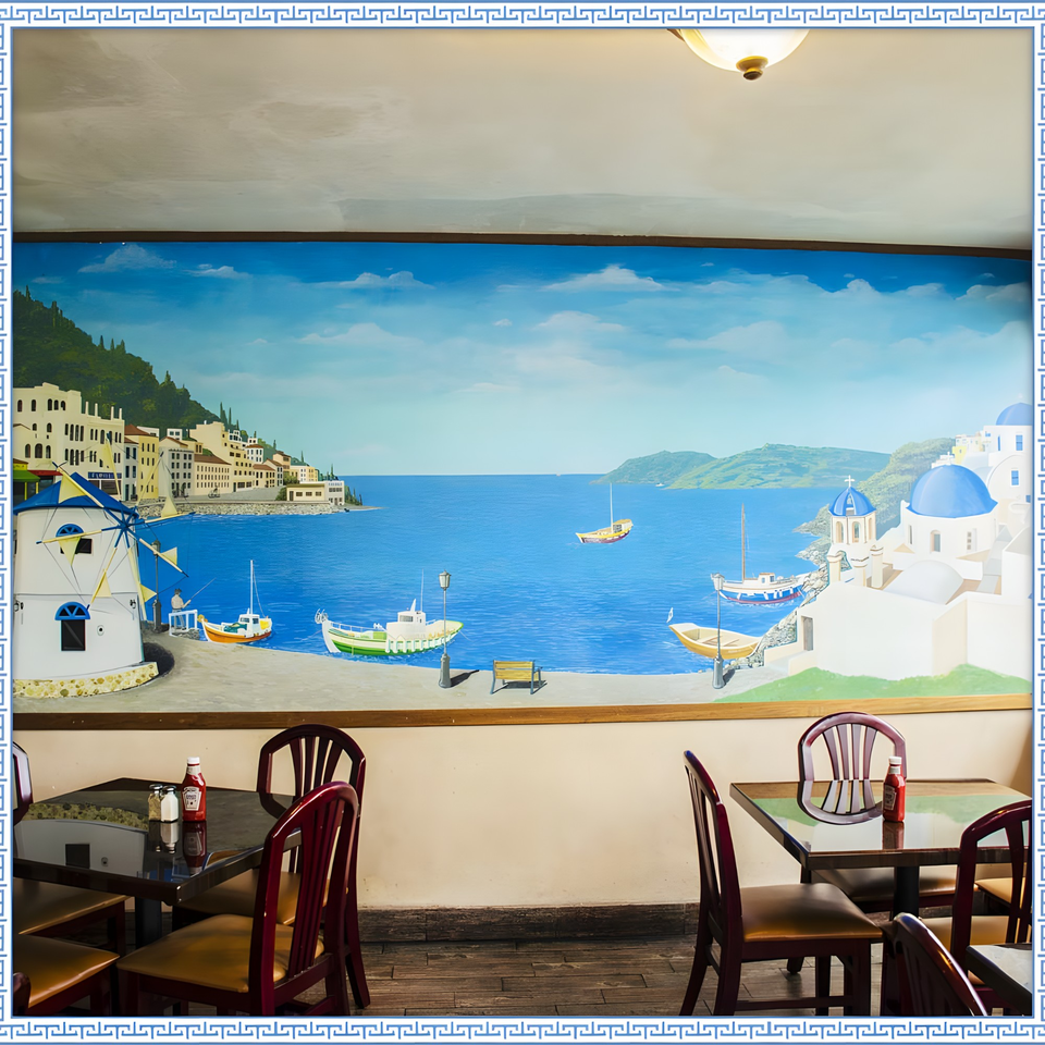 Restaurant interior with a large mural depicting a Greek coastal village scene with boats and windmills.